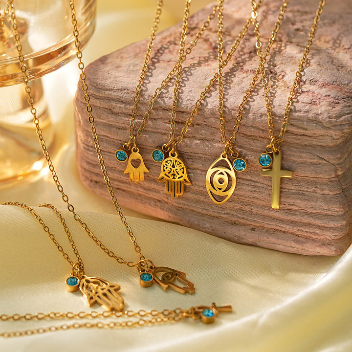 Collier à breloques Olivenorma avec croix aigue-marine et symbole du mauvais œil Hamsa