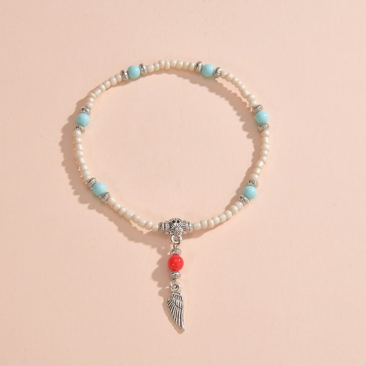 Bracelet de cheville avec pendentif plume en métal et perles turquoise blanches Olivenorma