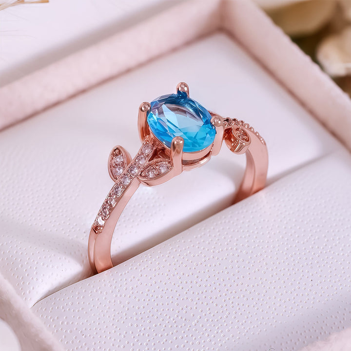 Bague Olivenorma avec topaze bleue taille ovale et feuille enveloppée