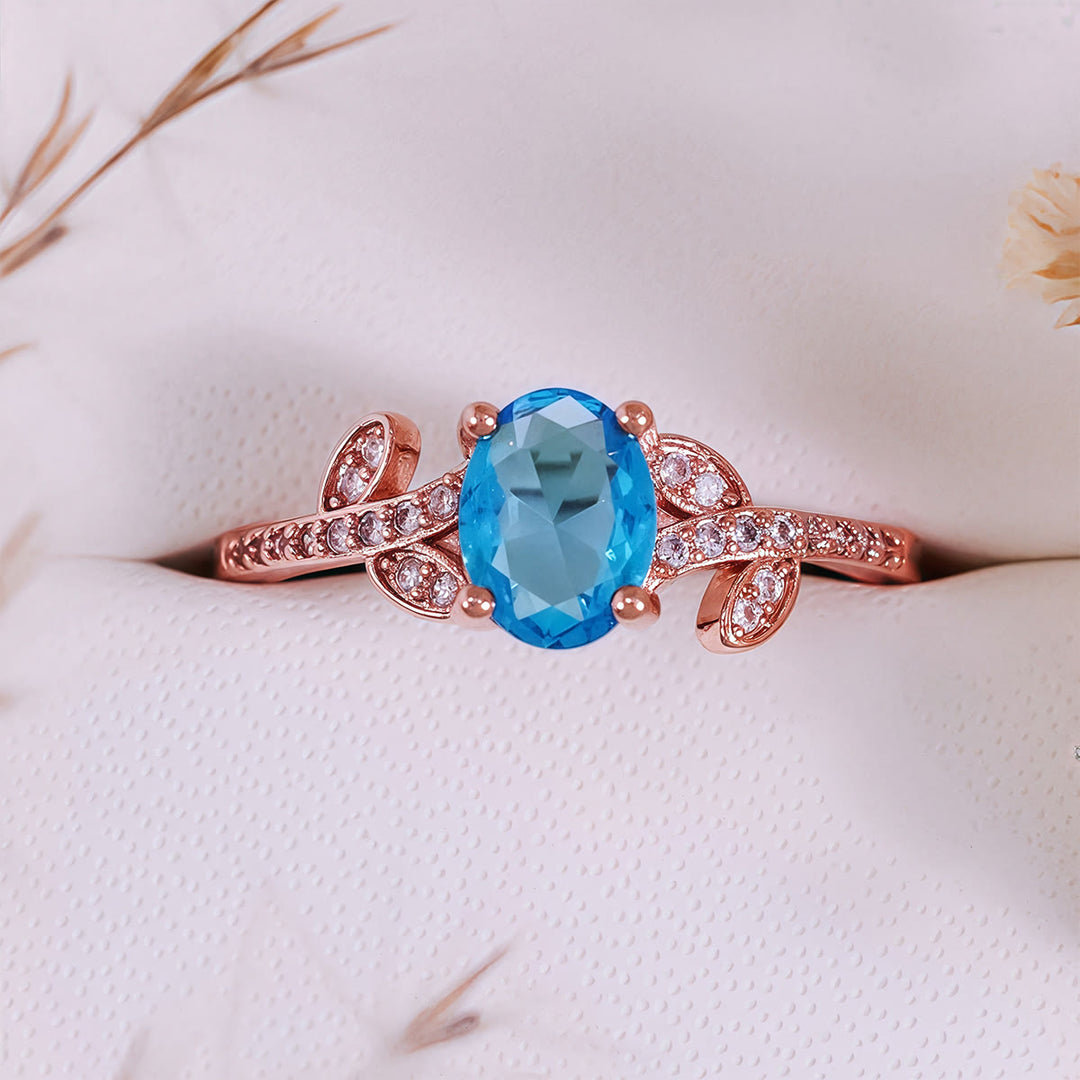 Bague Olivenorma avec topaze bleue taille ovale et feuille enveloppée