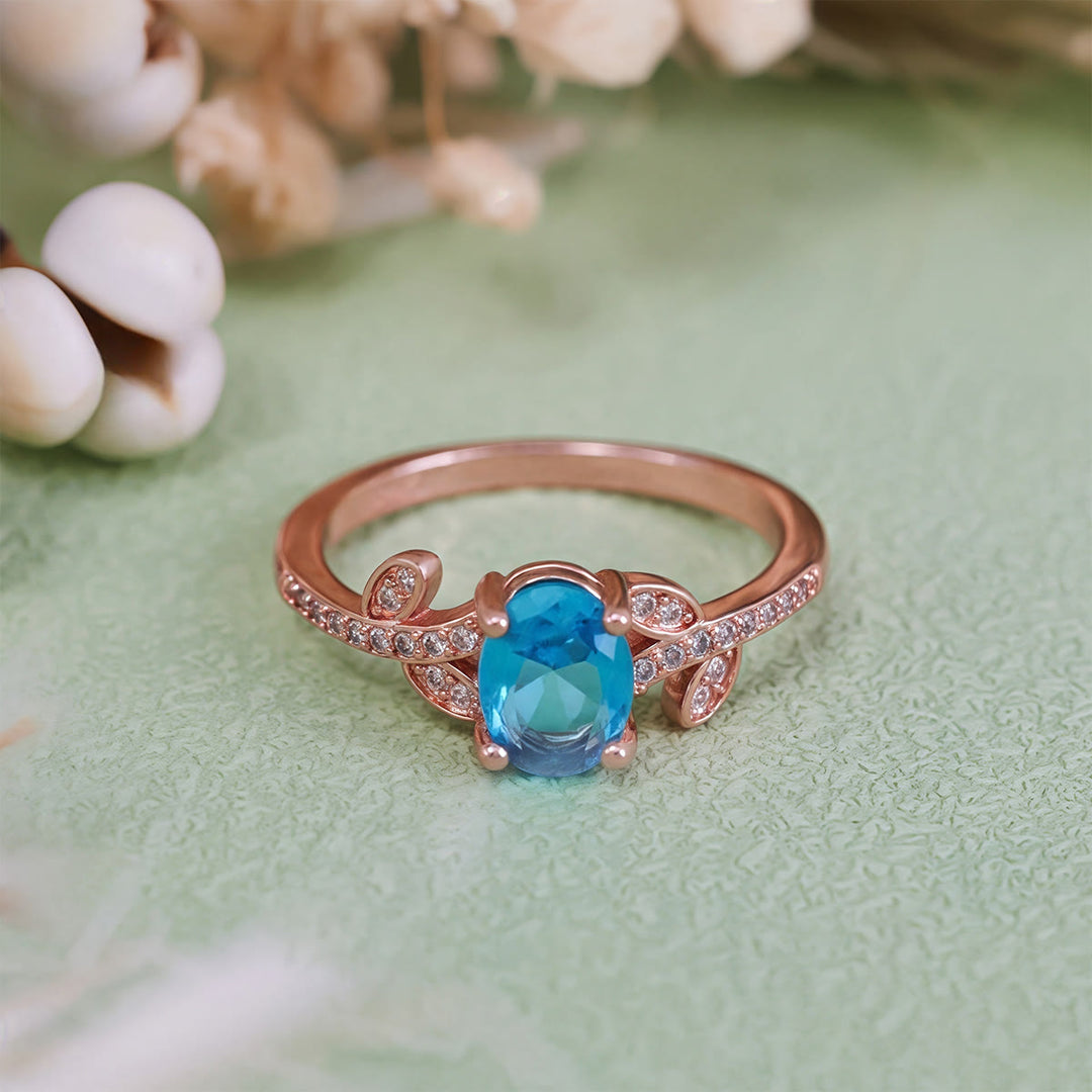 Bague Olivenorma avec topaze bleue taille ovale et feuille enveloppée