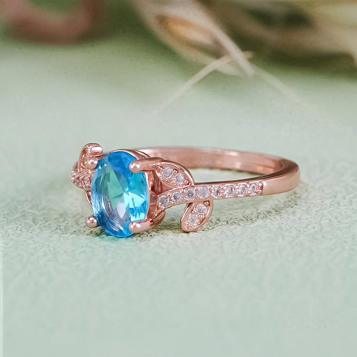 Bague Olivenorma avec topaze bleue taille ovale et feuille enveloppée