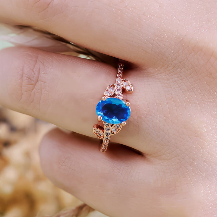 Bague Olivenorma avec topaze bleue taille ovale et feuille enveloppée