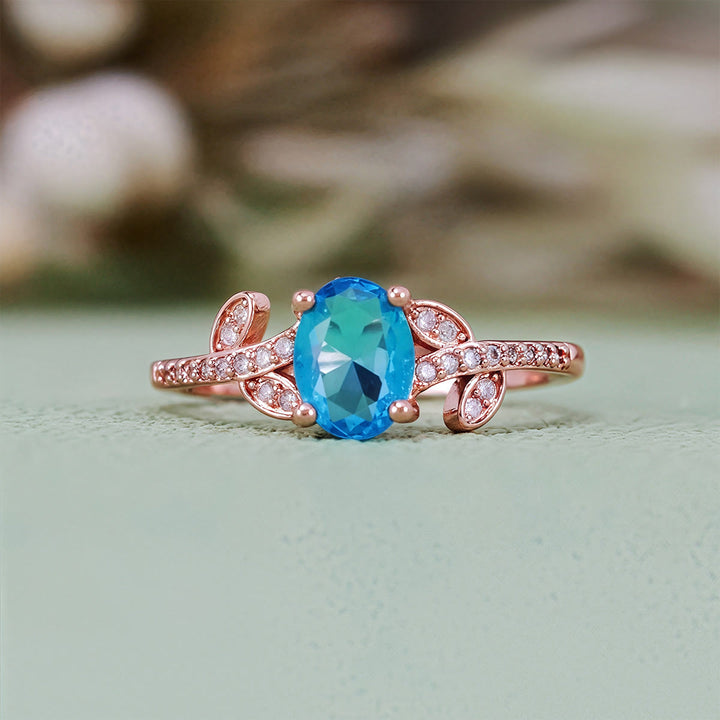 Bague Olivenorma avec topaze bleue taille ovale et feuille enveloppée