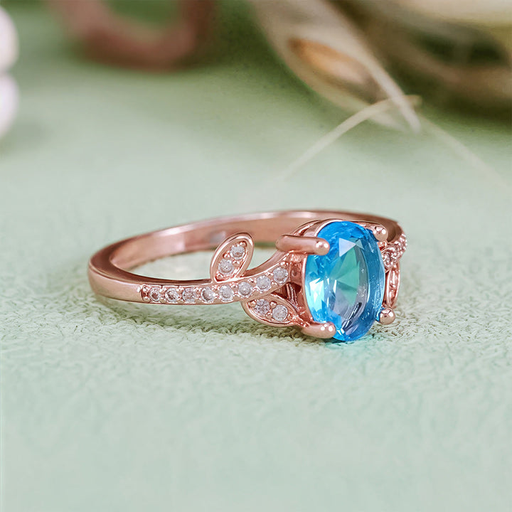 Bague Olivenorma avec topaze bleue taille ovale et feuille enveloppée