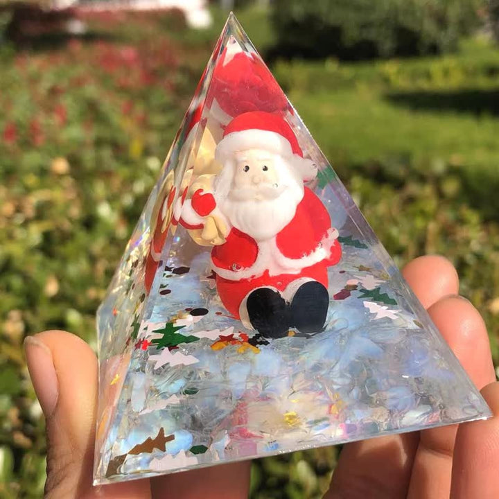 Père Noël Olivenorma avec pyramide d'orgone en pierre de lune