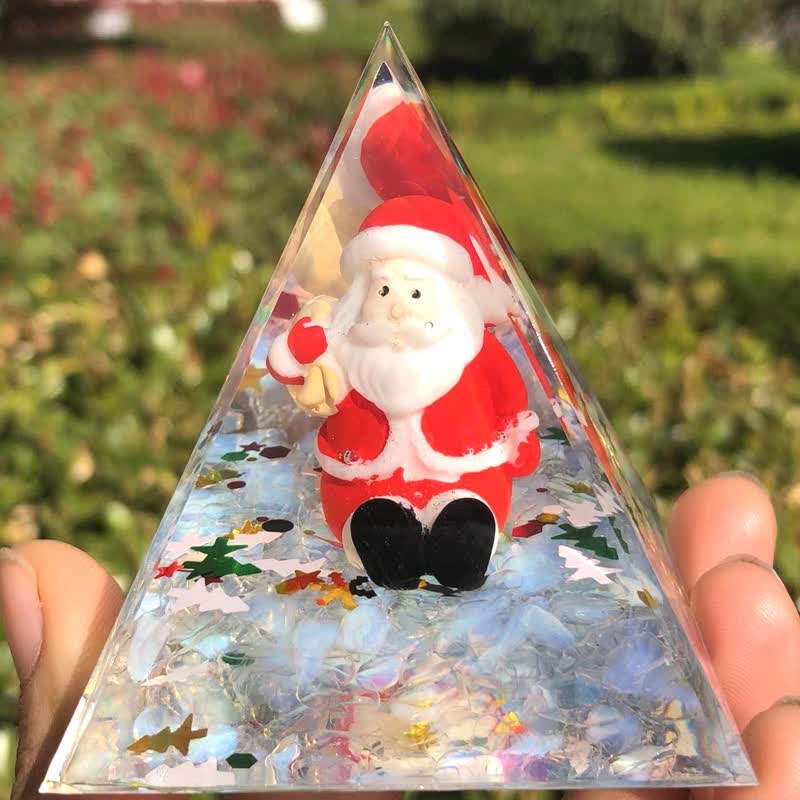 Père Noël Olivenorma avec pyramide d'orgone en pierre de lune