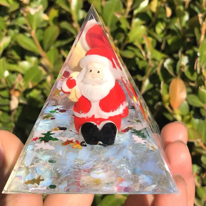 Père Noël Olivenorma avec pyramide d'orgone en pierre de lune