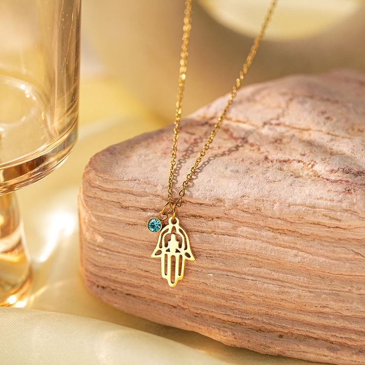 Collier à breloques Olivenorma avec croix aigue-marine et symbole du mauvais œil Hamsa