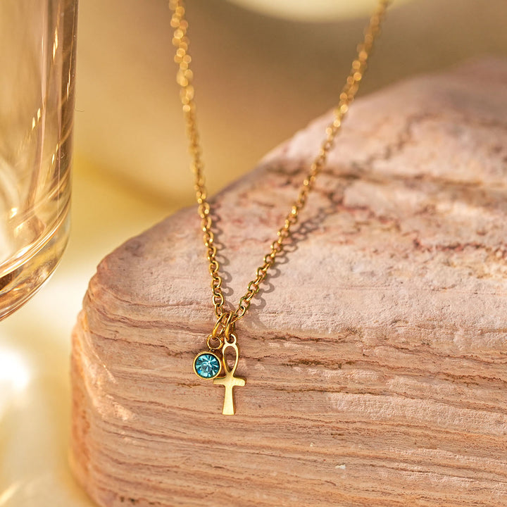 Collier à breloques Olivenorma avec croix aigue-marine et symbole du mauvais œil Hamsa