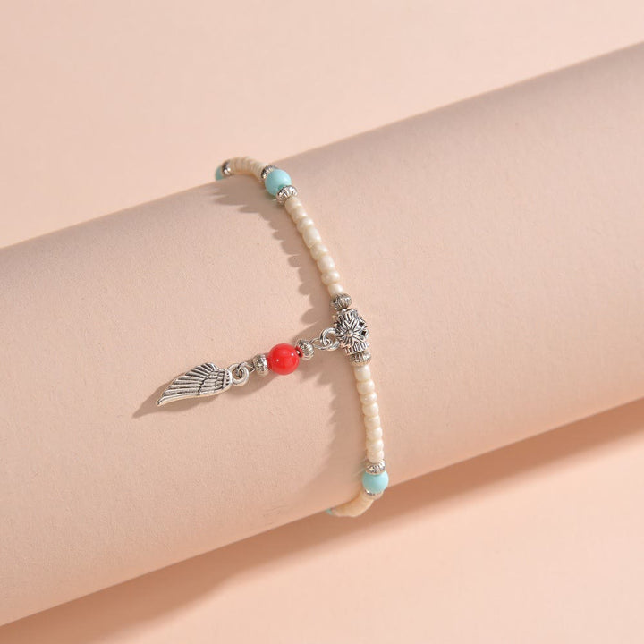 Bracelet de cheville avec pendentif plume en métal et perles turquoise blanches Olivenorma