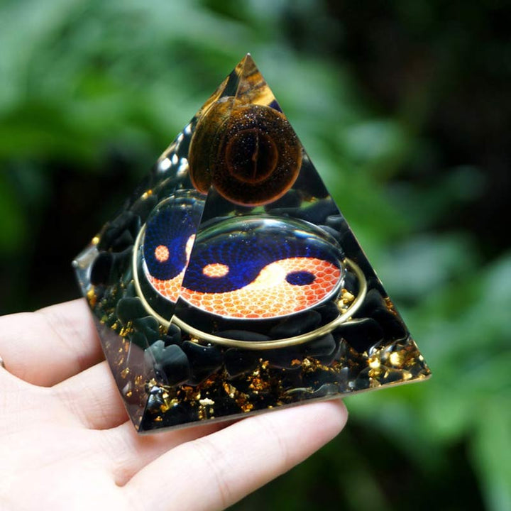 Sphère d'œil de tigre Olivenorma avec pyramide d'orgone Reki en obsidienne