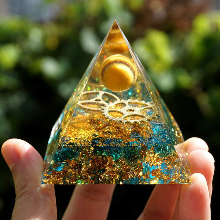 Sphère d'œil de tigre Olivenorma avec pyramide d'orgone en quartz bleu