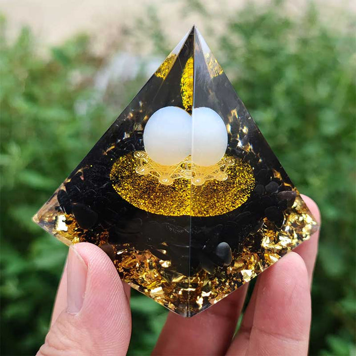 Sphère d'agate blanche Olivenorma avec pyramide d'orgone en obsidienne