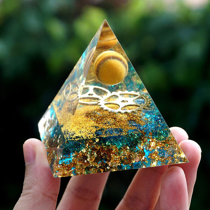 Sphère d'œil de tigre Olivenorma avec pyramide d'orgone en quartz bleu