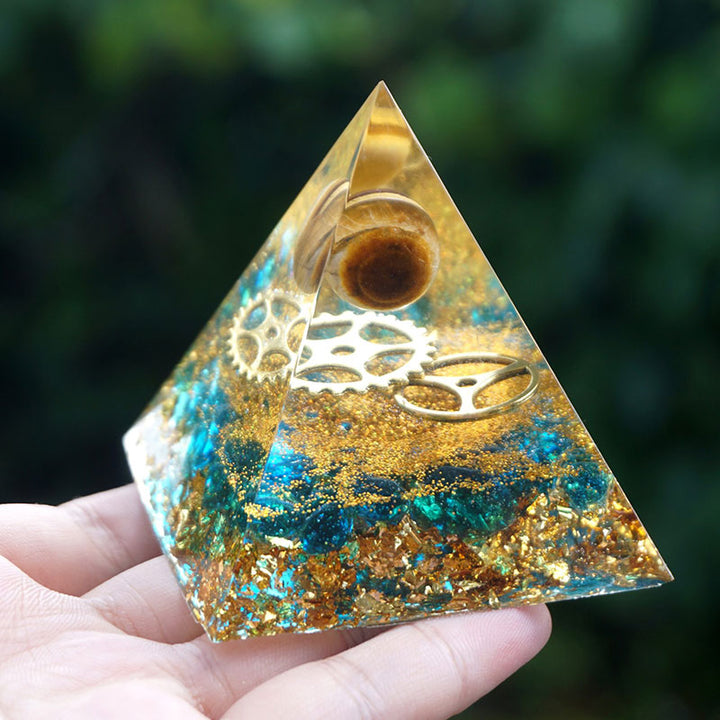 Sphère d'œil de tigre Olivenorma avec pyramide d'orgone en quartz bleu
