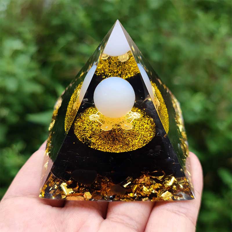 Sphère d'agate blanche Olivenorma avec pyramide d'orgone en obsidienne