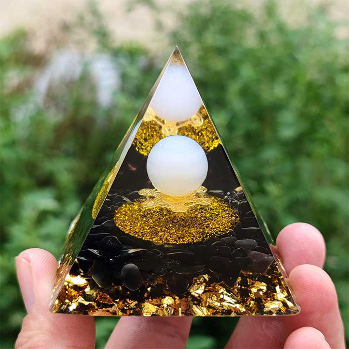 Sphère d'agate blanche Olivenorma avec pyramide d'orgone en obsidienne