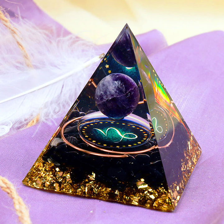 Sphère d'améthyste Olivenorma avec pyramide d'orgone du zodiaque Capricorne en obsidienne