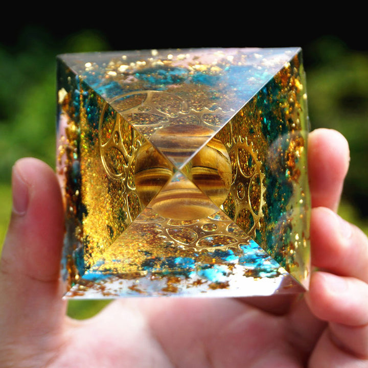 Sphère d'œil de tigre Olivenorma avec pyramide d'orgone en quartz bleu