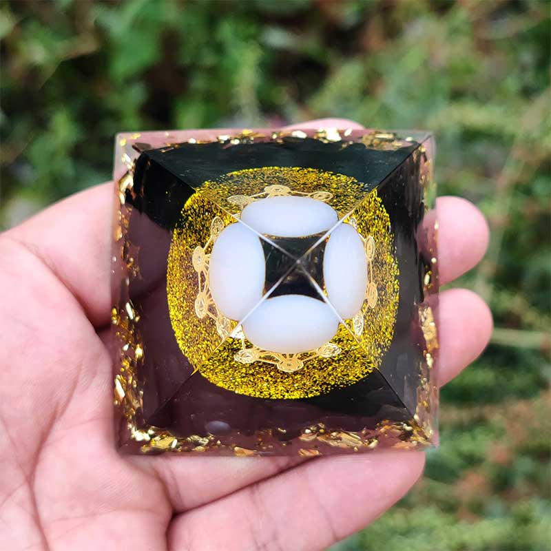 Sphère d'agate blanche Olivenorma avec pyramide d'orgone en obsidienne
